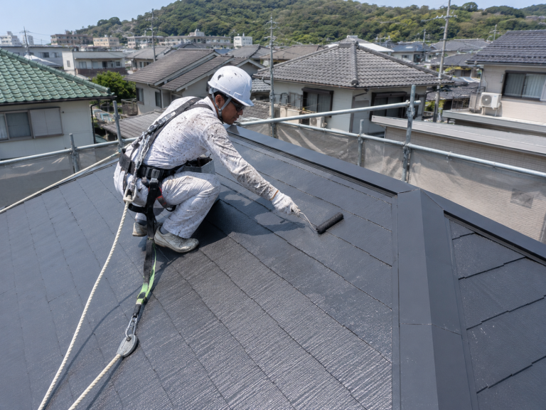 屋根をローラーで塗装している様子