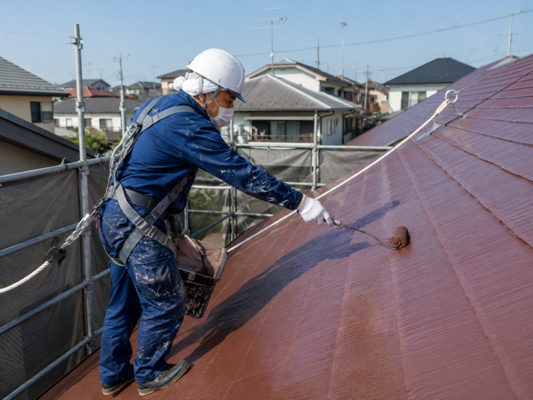屋根をローラーで塗装している様子